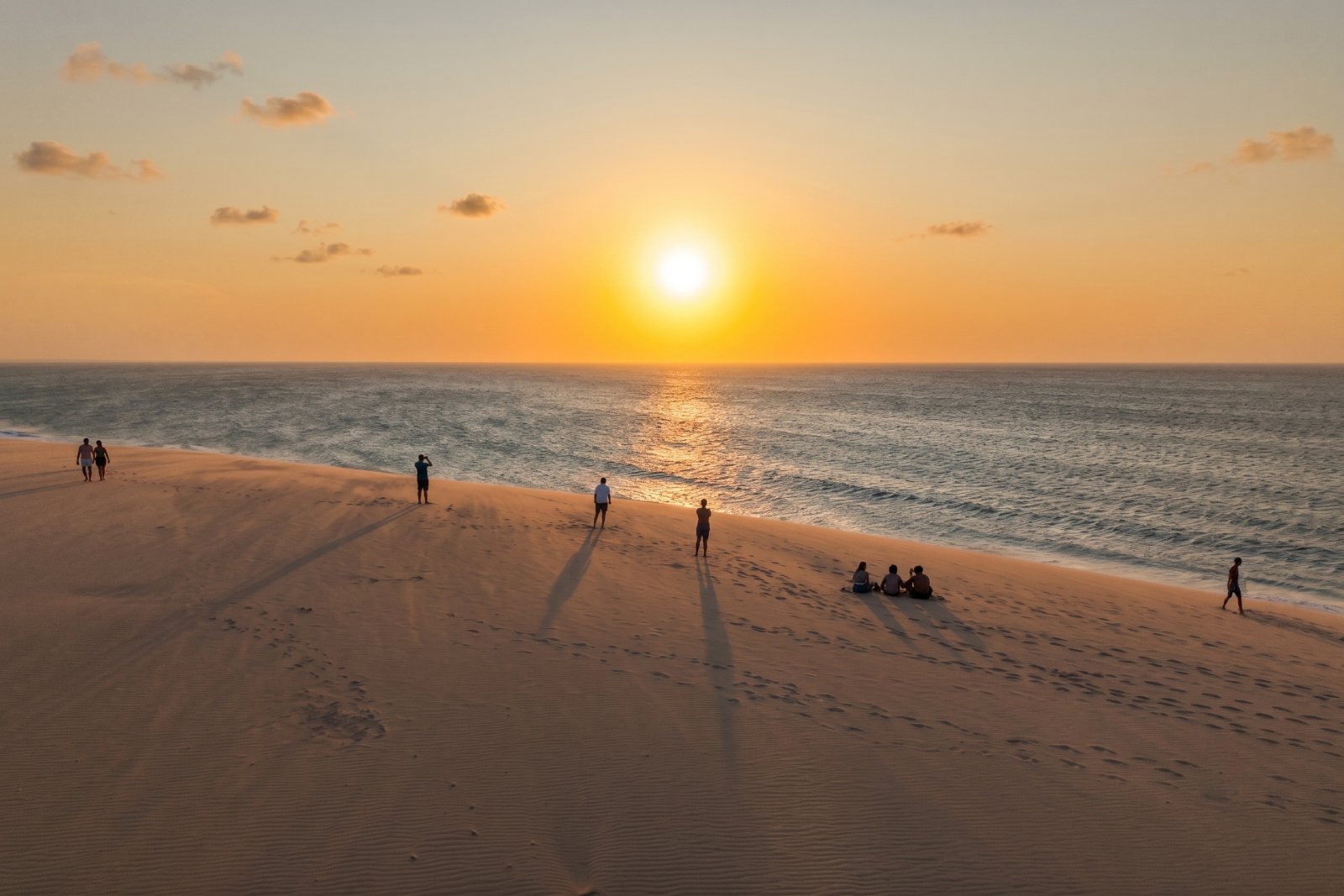 A Duna do Pôr do Sol com pessoas minúsculas na crista